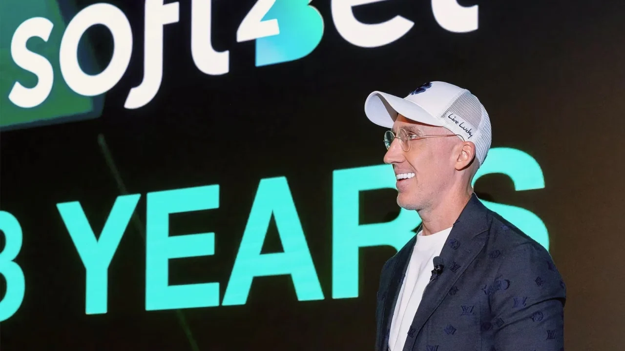 Uri Poliavich on stage in front of a Soft2Bet eight years anniversary backdrop
